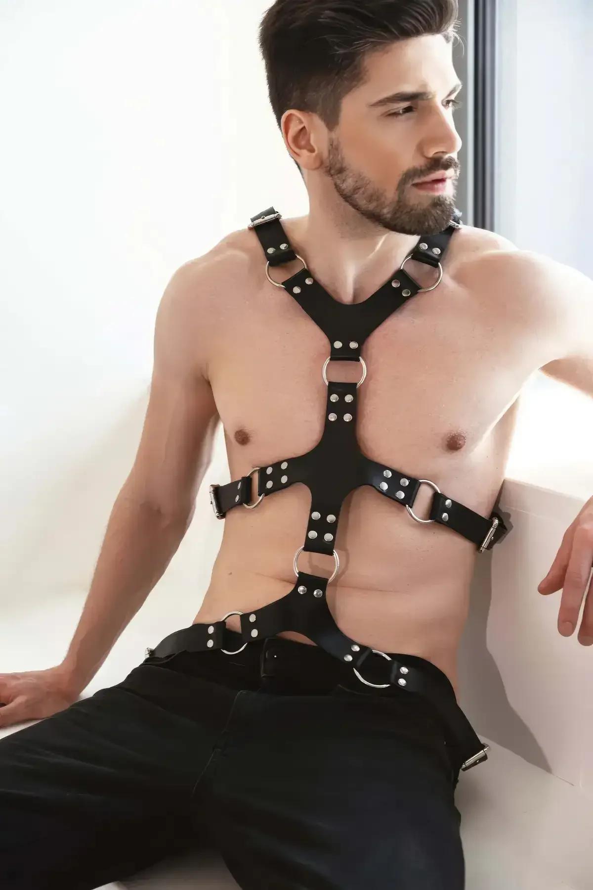 close-up of silver-tone O-ring and dome stud detail on black PU leather harness strap junction