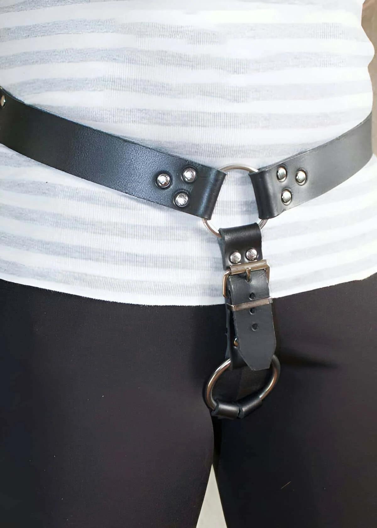 close-up of silver O-ring and dome rivets on black faux leather waist harness strap
