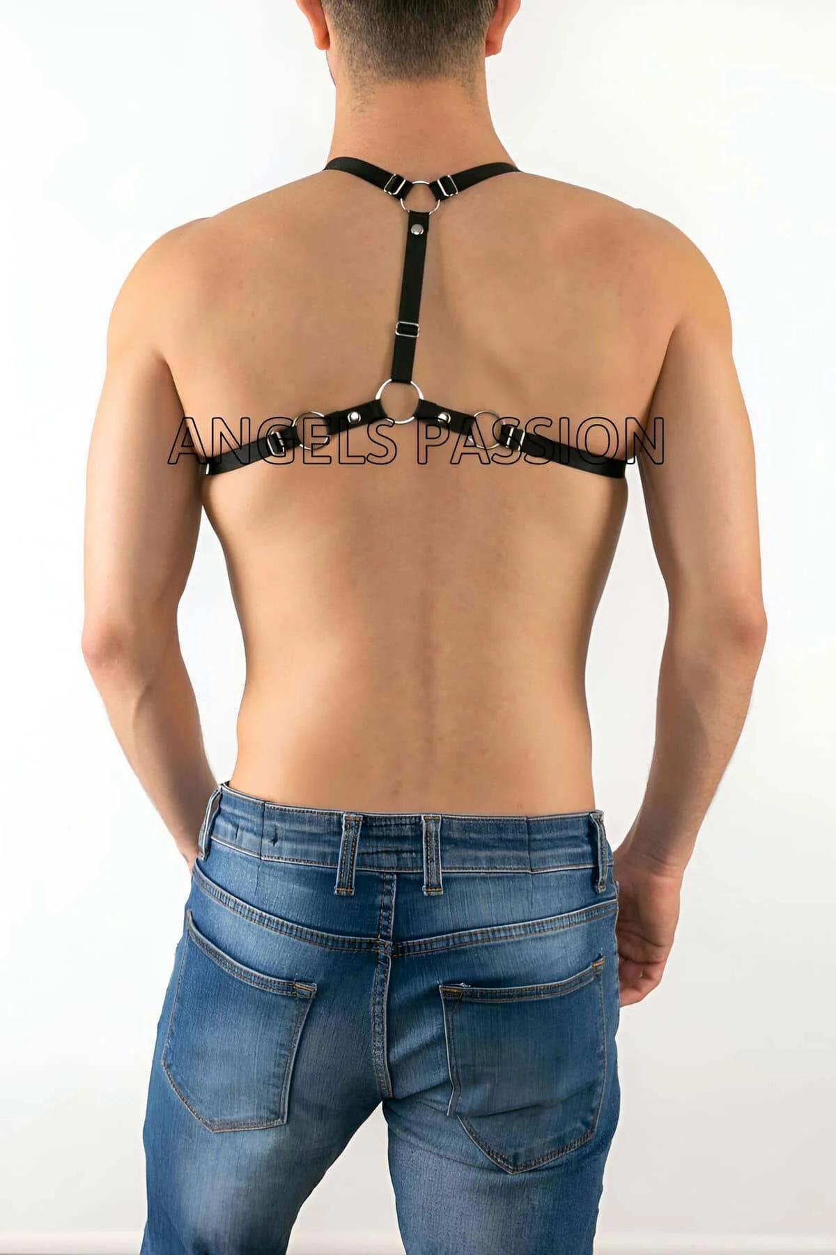 lower section of black cage harness showing silver O-ring and D-rings with neon green rope trailing down