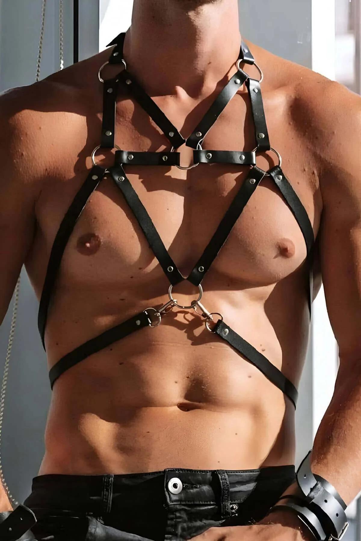 Close-up of gold O-ring hardware on black faux leather chest harness strap junction