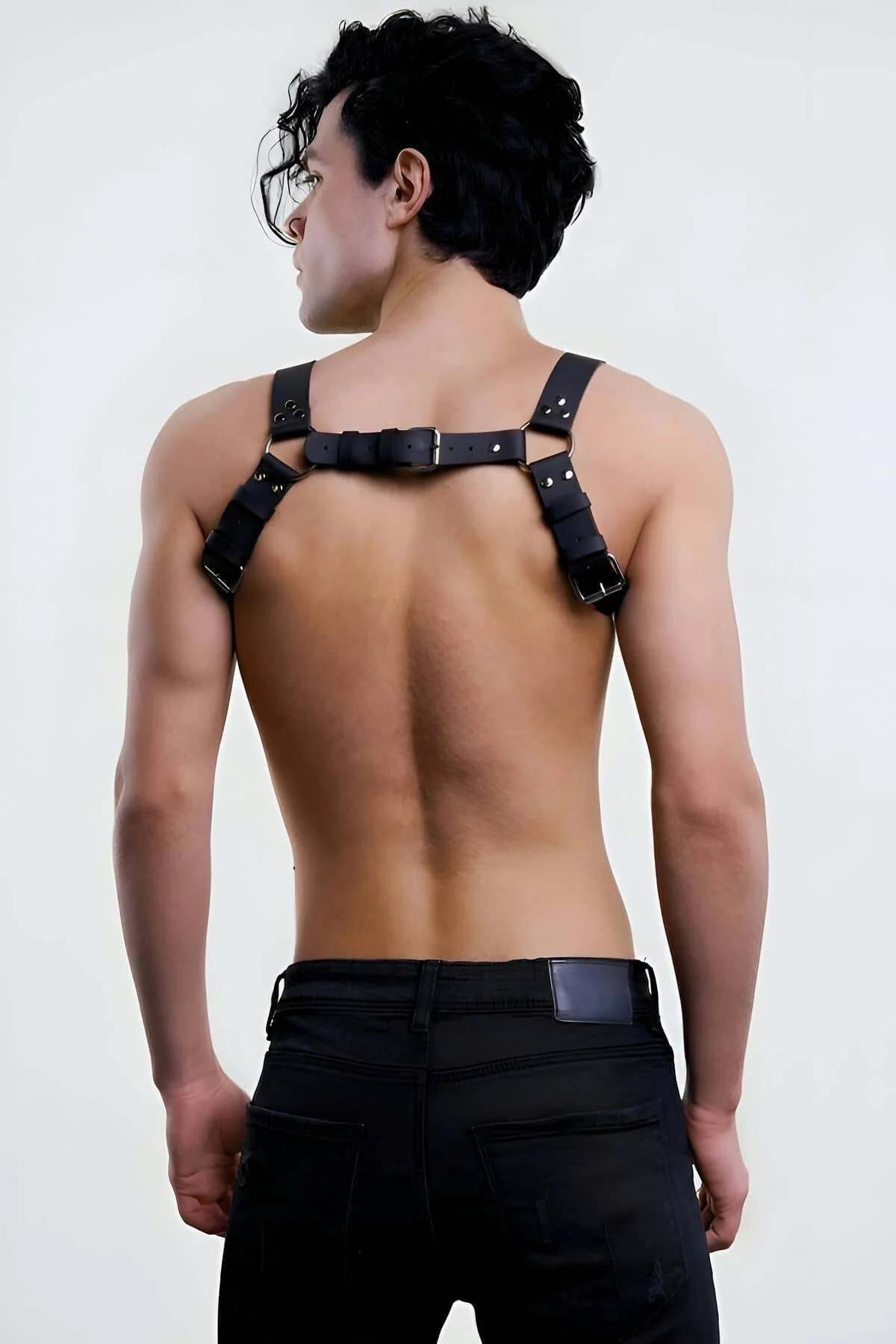 Close-up of gold-tone O-ring and rivet detail on black PU leather chest harness center band