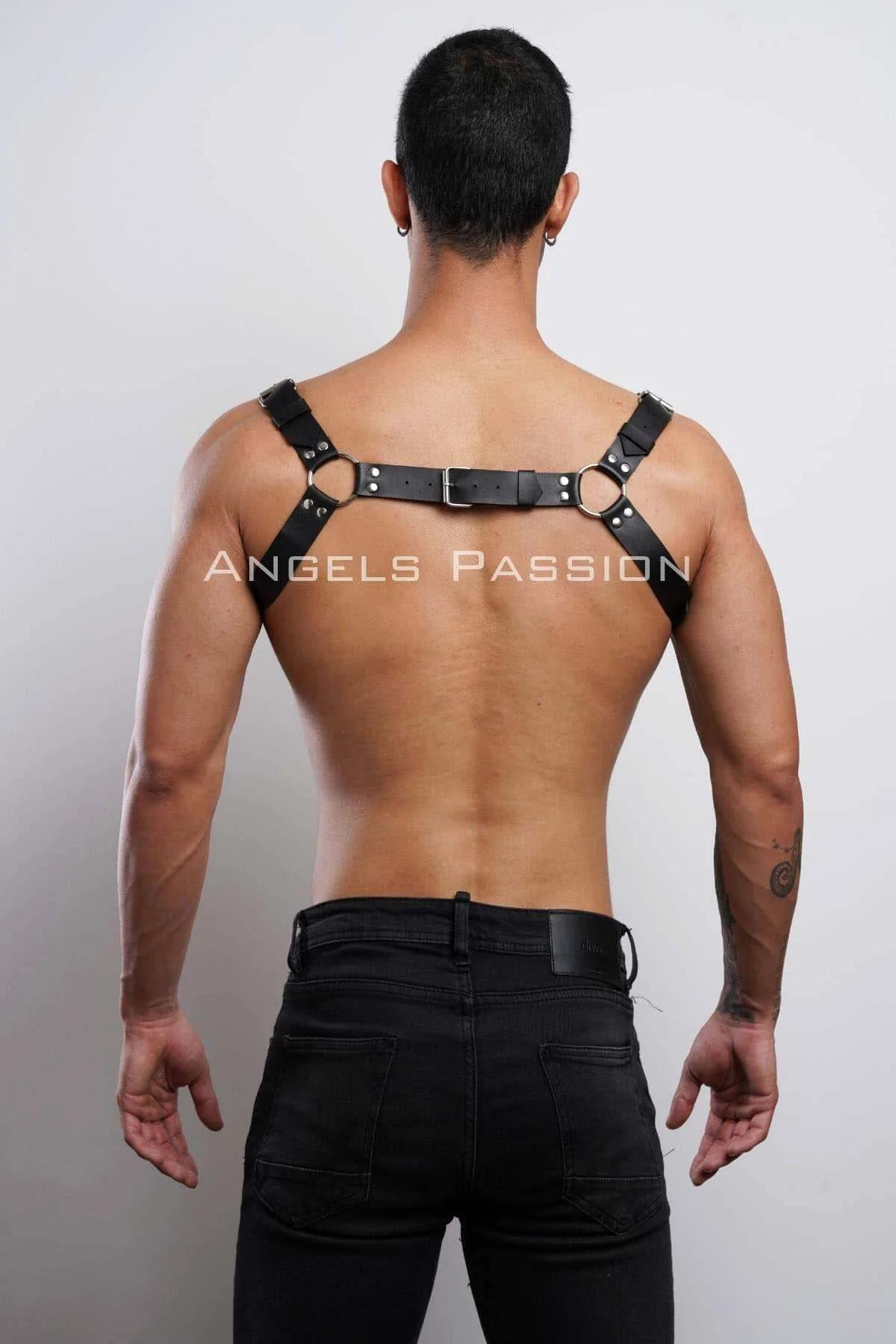 Black chest harness with gold O-rings styled over bare chest with dark jeans festival look