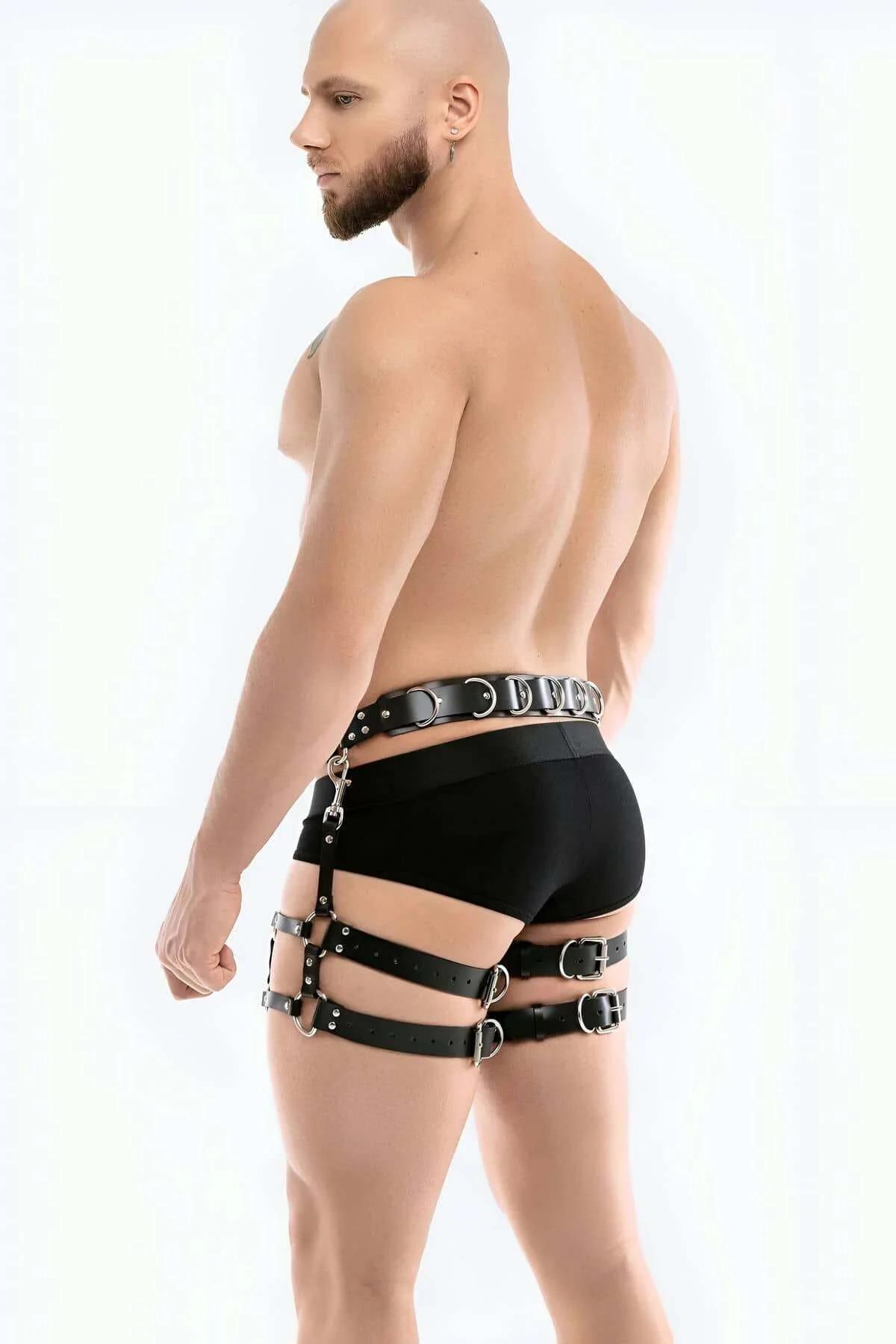 side view of black thigh harness showing three horizontal strap bands and riveted hardware
