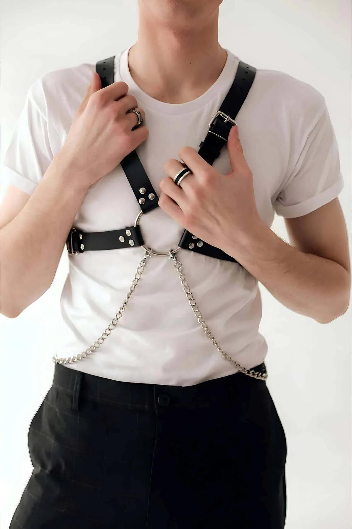 close-up of silver O-ring and chain on black faux leather chest harness