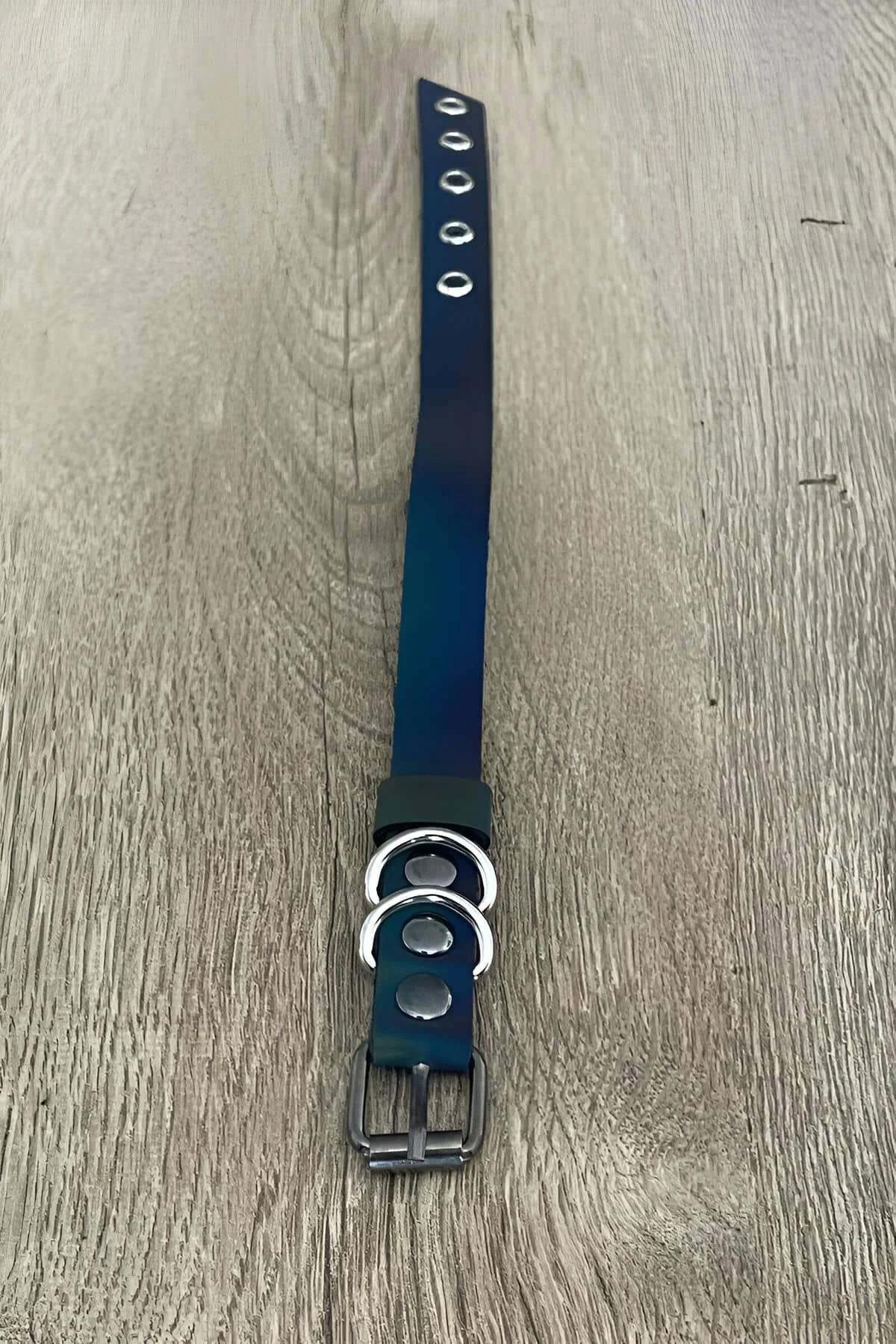 Close-up of two silver O-rings on iridescent teal faux leather finger strap buckle detail