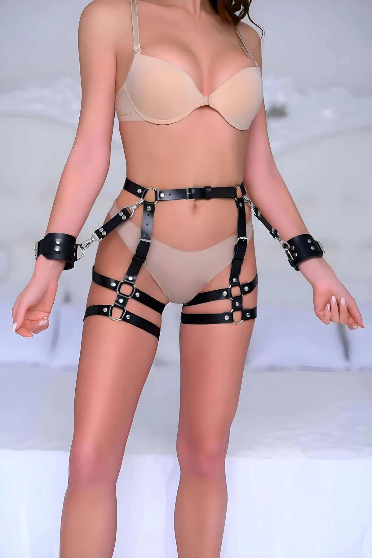 Black faux leather thigh harness with dual leg bands, waist belt, and detachable silver-hardware wrist cuffs worn as a full s