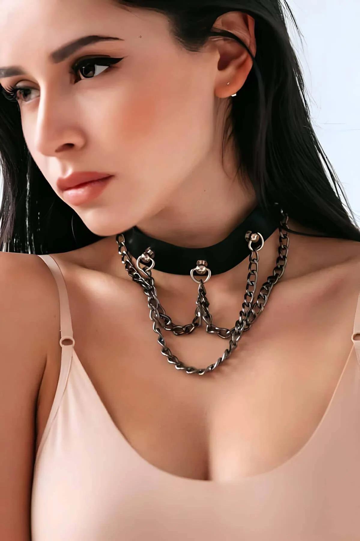 Black faux leather wide band choker with three draped gunmetal curb-link chains and O-ring hardware on model