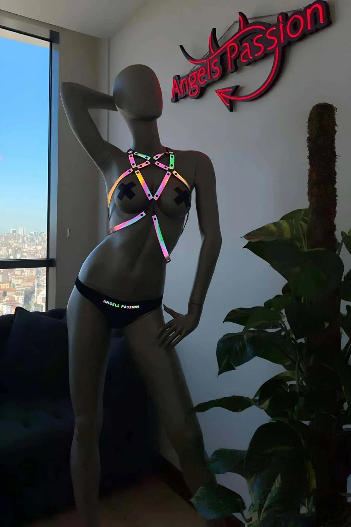 Rainbow reflective body harness with iridescent holographic cage straps and silver square hardware on mannequin