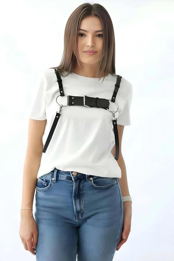 black faux leather chest harness with wide front buckle panel and dual silver O-rings worn over white tee
