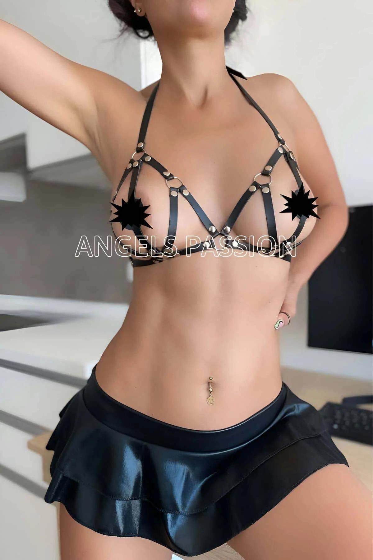 Black faux leather strappy bra harness with silver O-ring hardware and cage strap construction, halter neck style