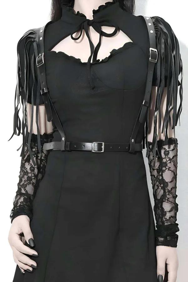 Black faux leather body harness with long fringe shoulder straps and silver-tone buckle waist band worn over black top