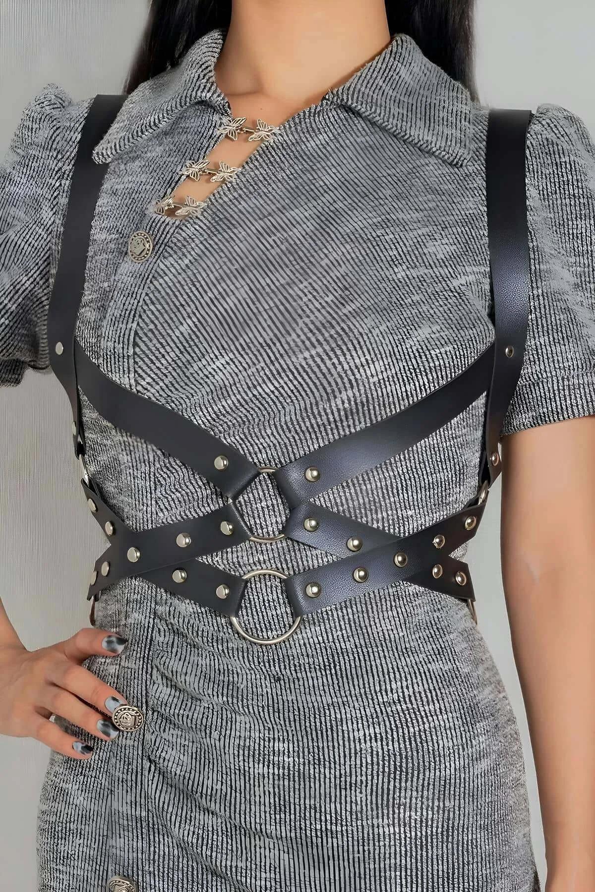 black faux leather studded O-ring body harness with silver dome studs worn over gray knit dress
