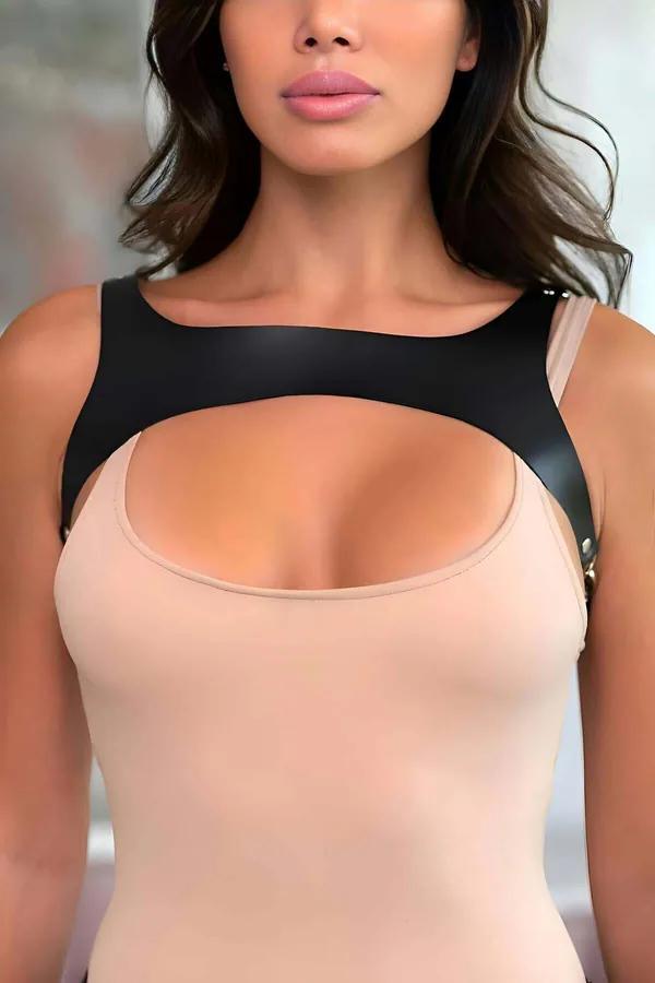 black faux leather chest harness with scoop cutout and gold-tone stud hardware worn over nude bodysuit