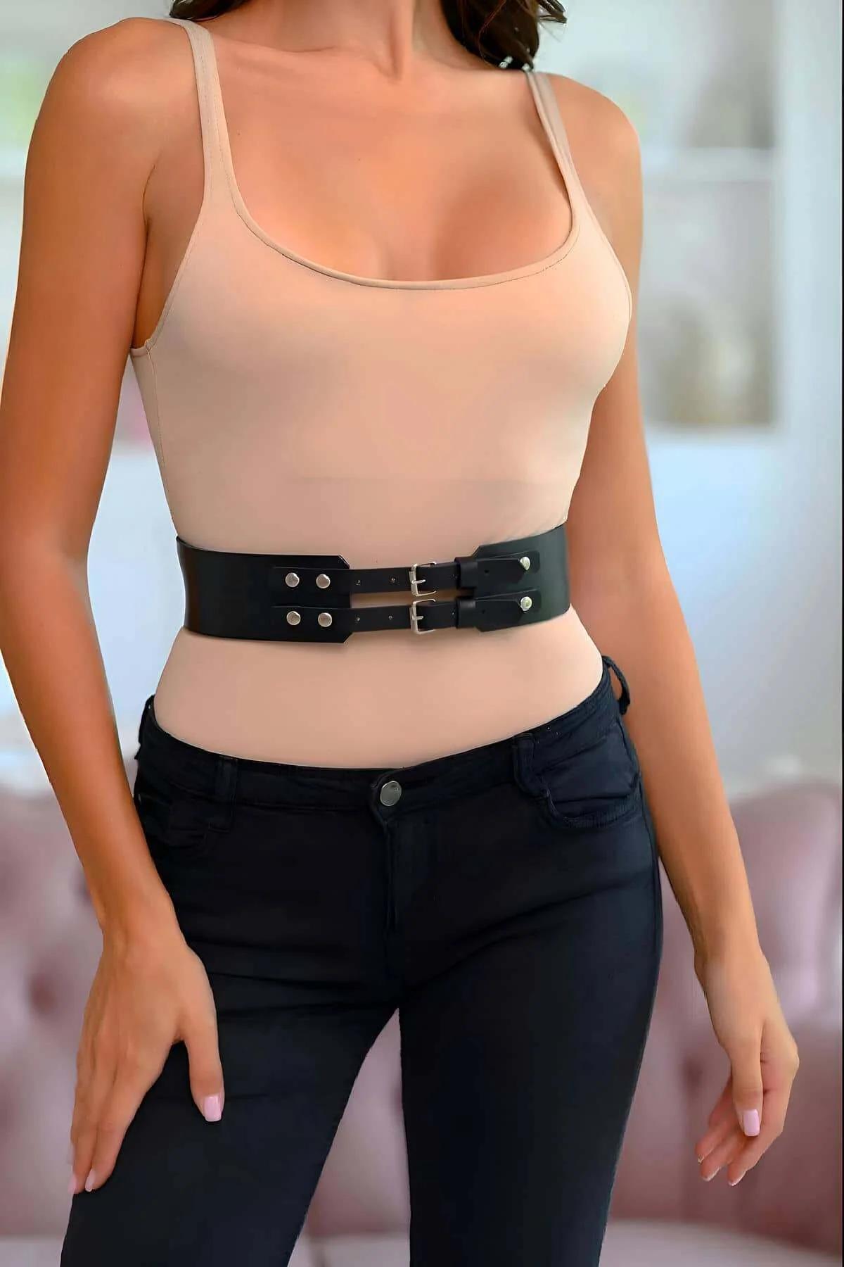 black faux leather wide waist belt with dual silver pin buckles worn over beige bodysuit