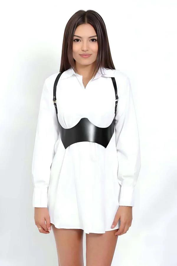 black faux leather contoured corset body harness with gold hardware shoulder straps worn over white shirt dress