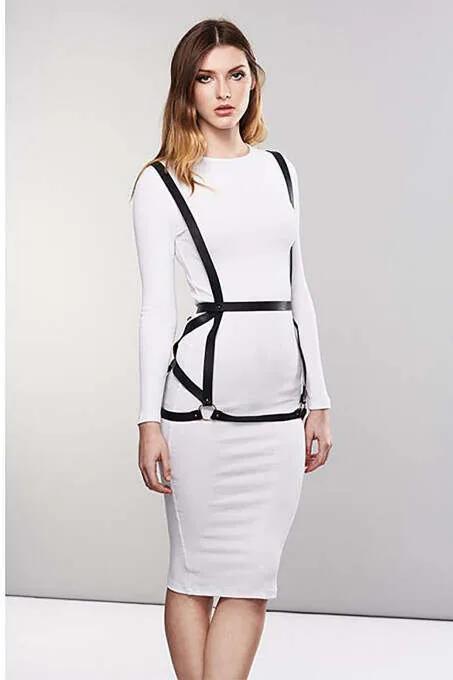 black faux leather body harness with silver O-ring waist belt worn over white fitted dress, front view
