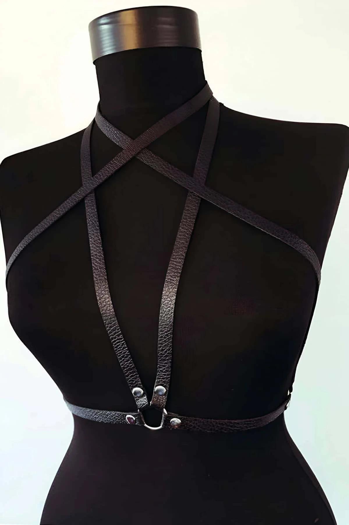 black faux leather starburst chest harness with silver O-ring displayed on mannequin, front view