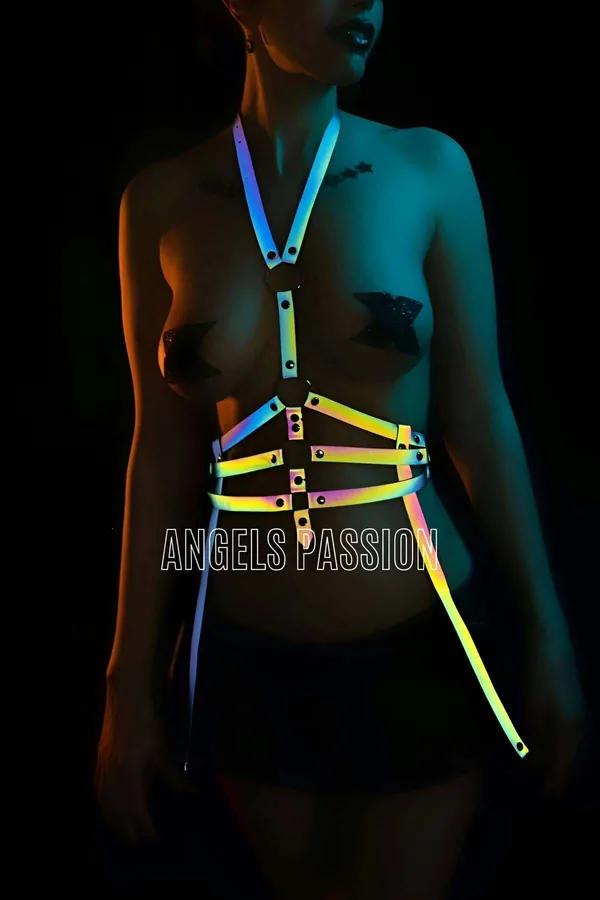 Holographic reflective body harness rainbow-spectrum straps glowing green yellow orange under stage lighting full chest and w
