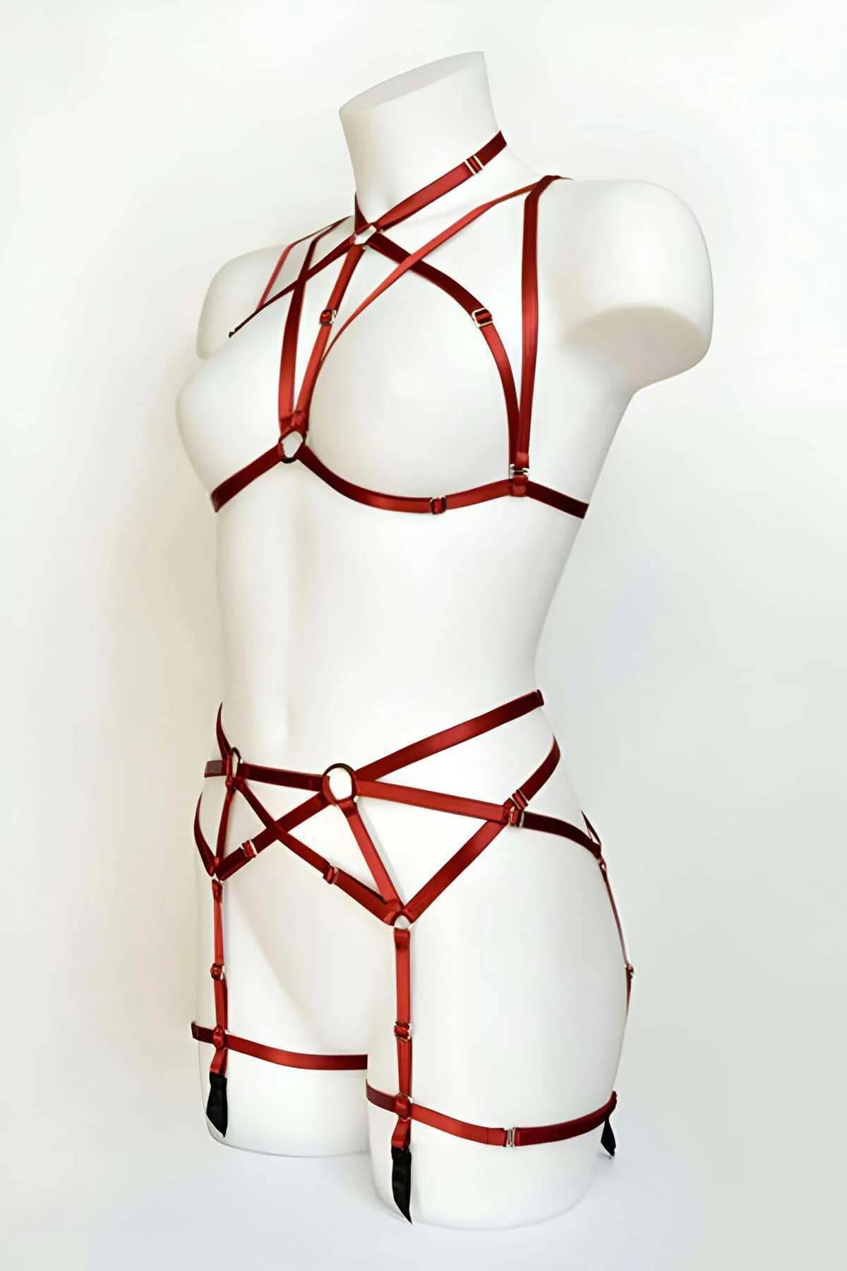 Red satin elastic strappy harness set with gold O-ring accents on chest, waist and thigh garters on white mannequin