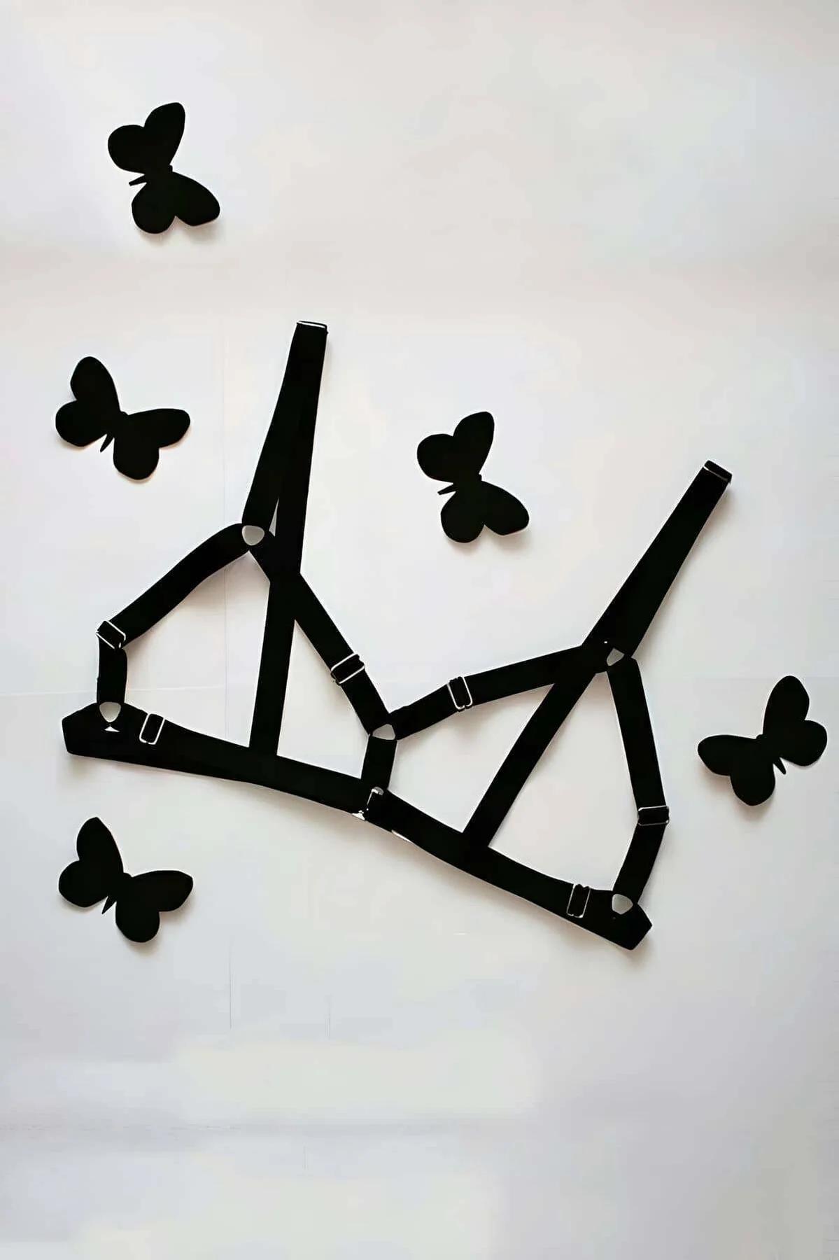 black elastic strappy cage bra harness with geometric triangular panels and silver slide buckle adjusters laid flat
