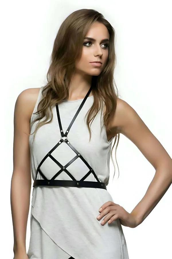 Black faux leather body harness with diamond lattice chest grid and brass rivet studs worn over white tank top