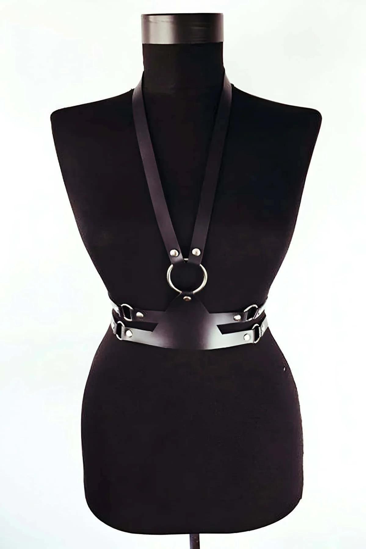 Black faux leather body harness with silver O-ring chest detail and wide adjustable waist belt on dress form
