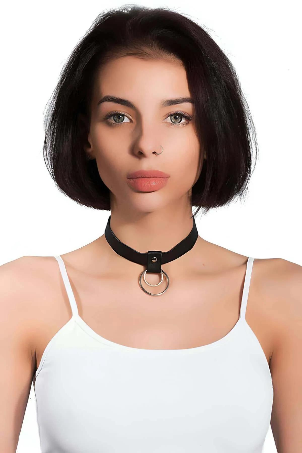 Black faux leather choker necklace with two stacked silver O-rings worn at collarbone, matte band approximately 2.5 cm wide