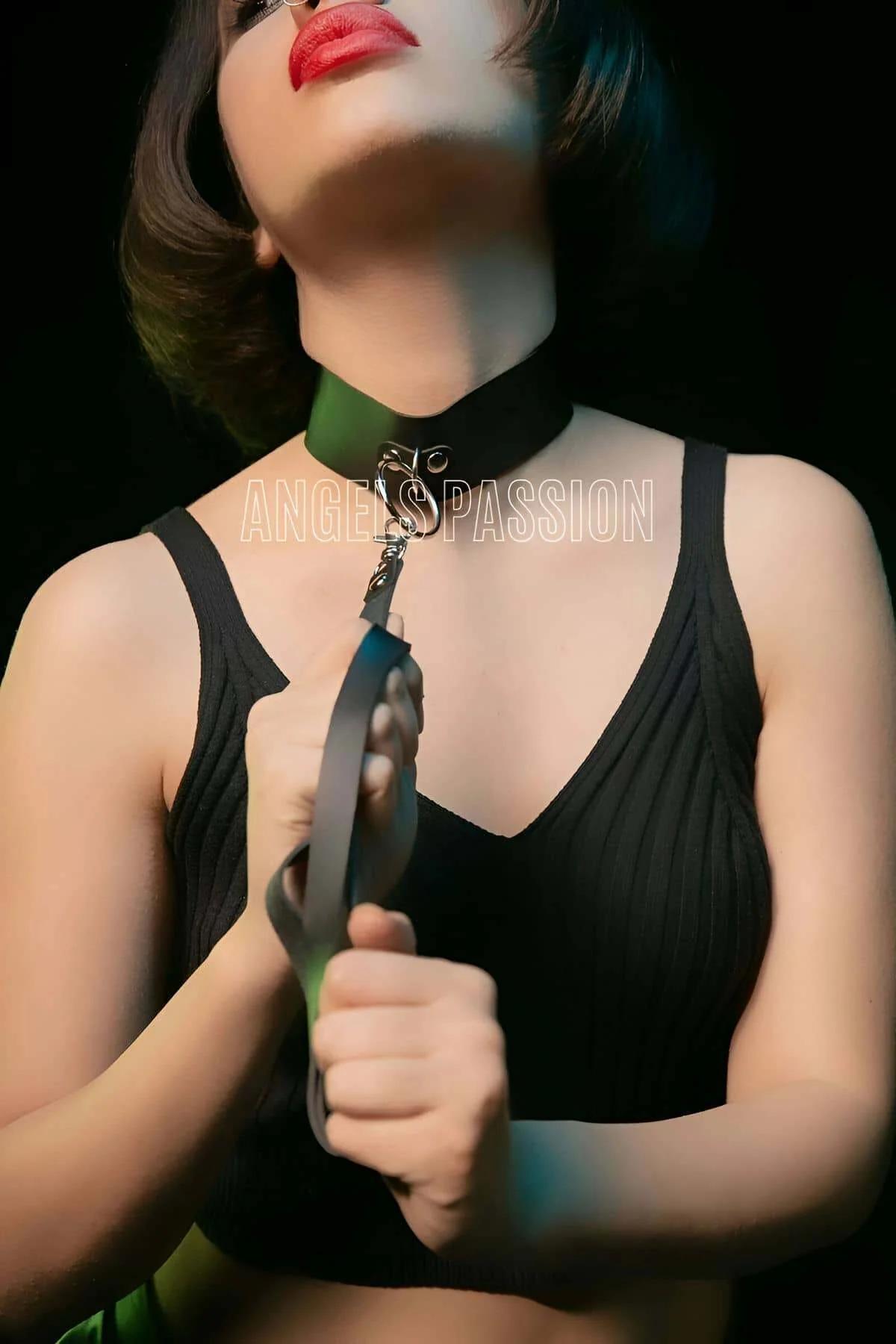 black faux leather choker collar with silver D-ring and detachable flat leash strap held in hand