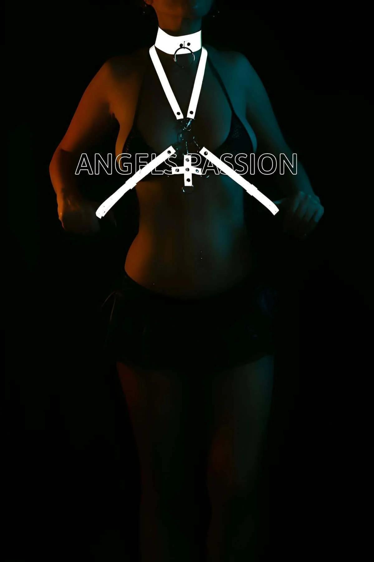 White reflective body harness with wide choker and cross-body X-strap design glowing under dark blue stage lighting