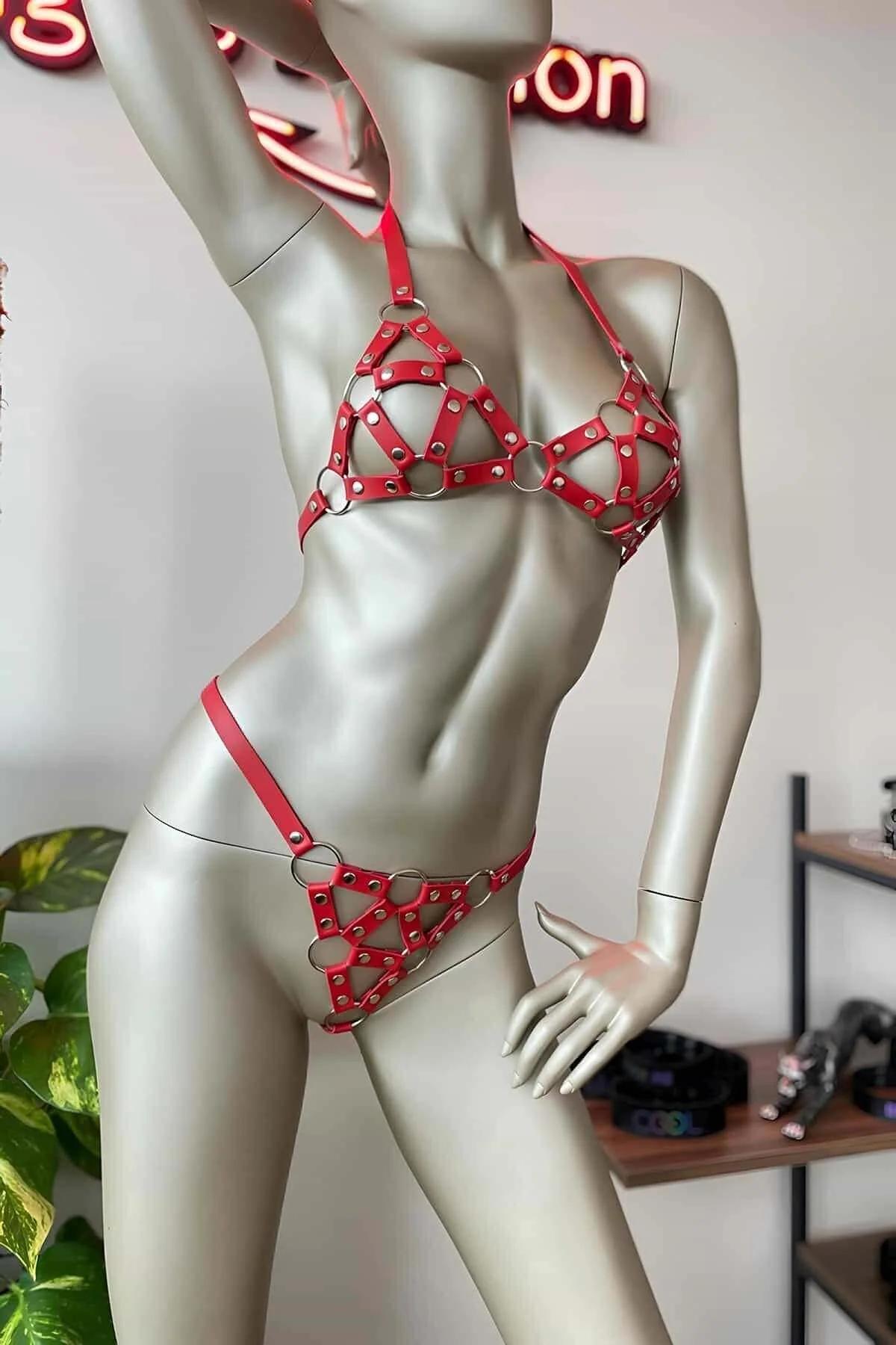 Red faux leather caged bra and thong harness set with silver O-rings and rivet hardware on mannequin