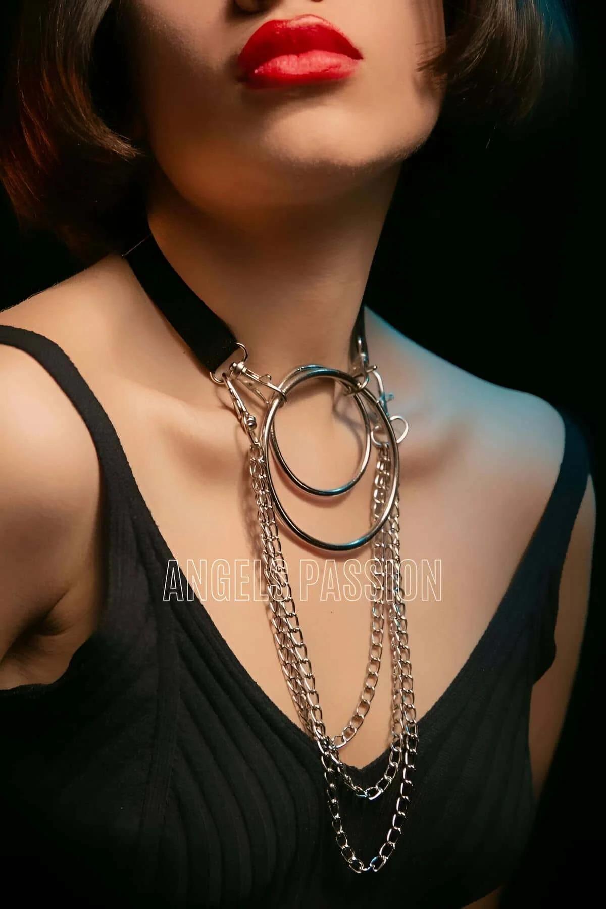 Black faux leather choker necklace with stacked silver O-rings and four cascading curb-link chain strands draped on chest