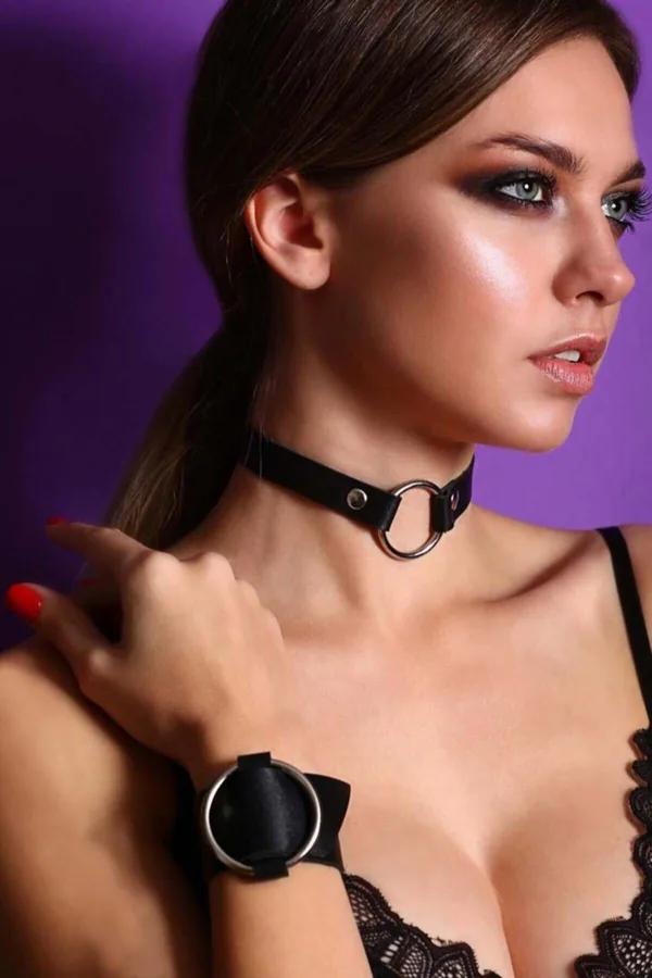 Black faux leather O-ring choker and wrist cuff set with polished silver hardware worn together