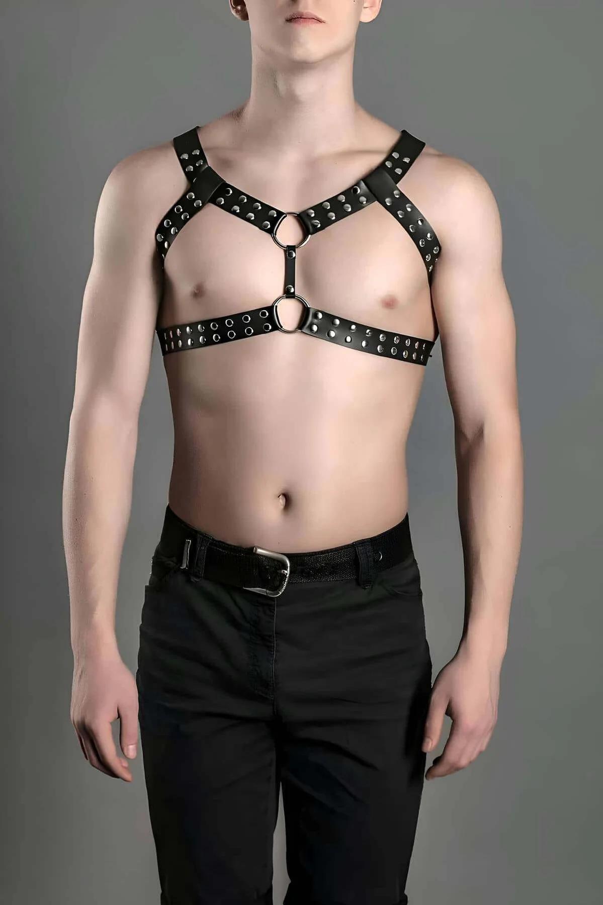 black faux leather chest harness with dual silver O-rings and dome studs in X-strap configuration on male model