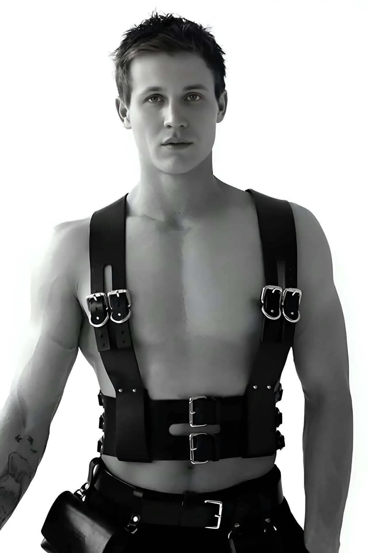 Black faux leather chest harness with dual silver buckles on chest and wide waist belt worn by male model