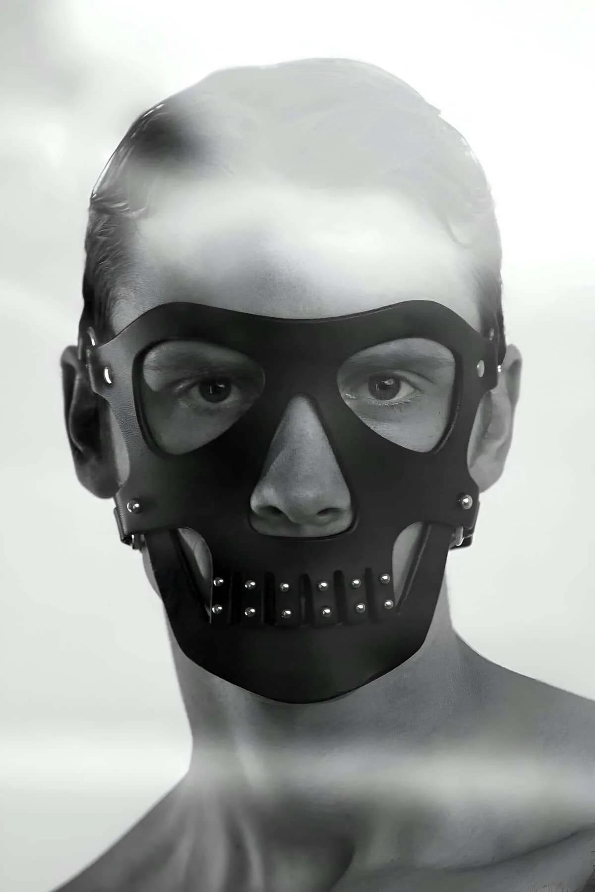 black faux leather skull mask with silver dome studs on jaw panel and open eye socket cutouts shown on mannequin