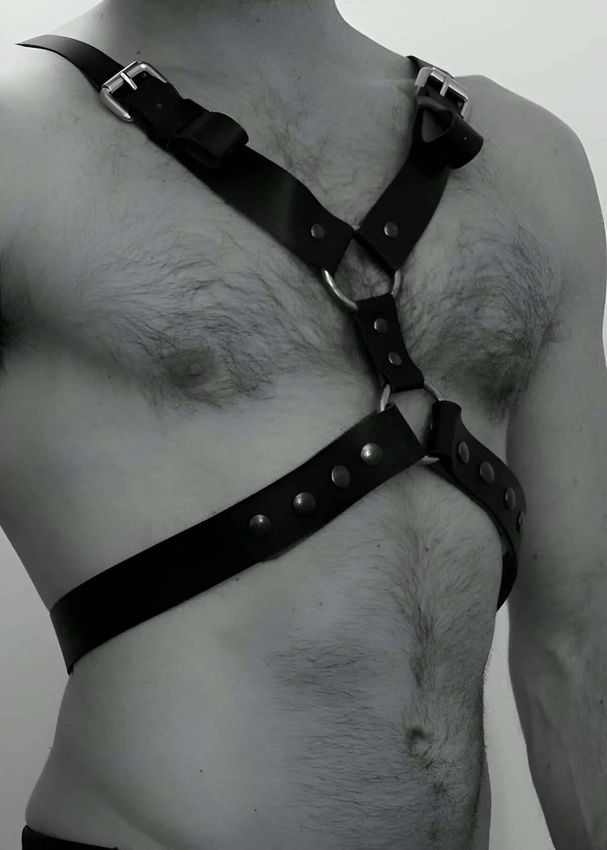 black faux leather chest body harness with silver buckles and center O-ring worn on male torso