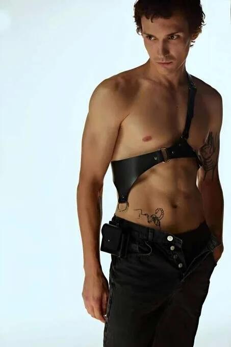 black faux leather body harness with gold O-ring and square buckle single-shoulder diagonal strap on male model