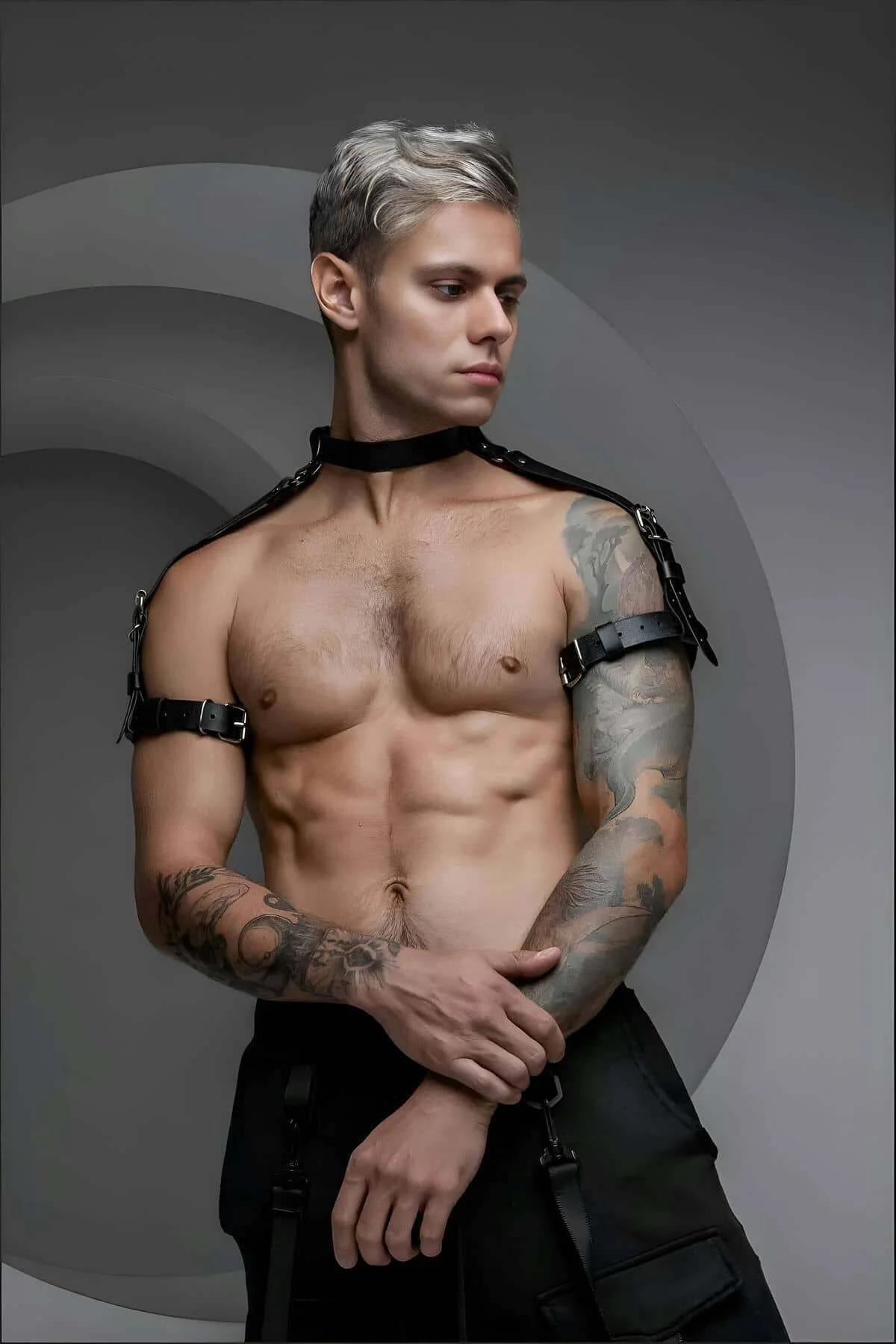 Black faux leather choker and shoulder harness set with silver buckles on male model, matte strap finish