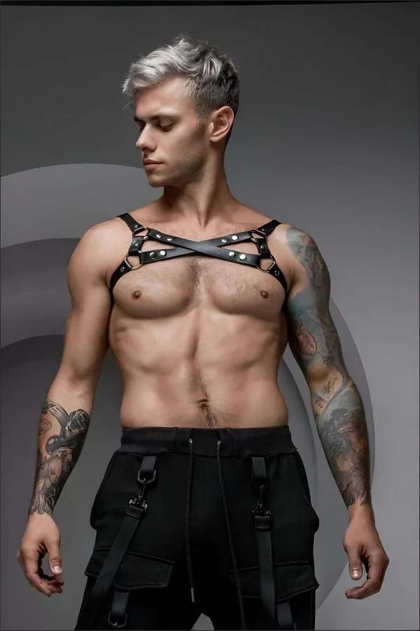 black faux leather chest harness crossed X-strap design with silver O-rings worn by male model