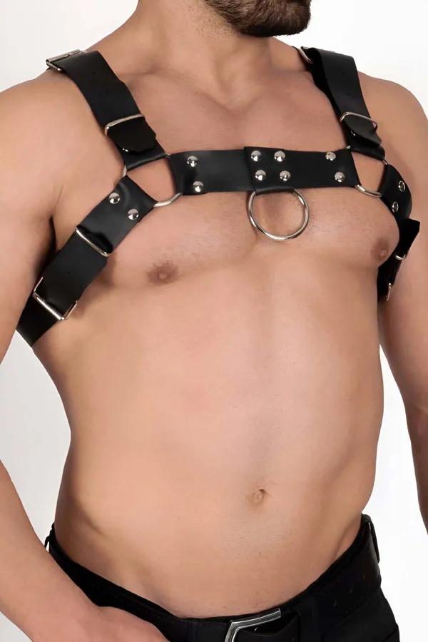 black faux leather chest harness with centered silver O-ring, dome rivets and adjustable buckle straps on male torso