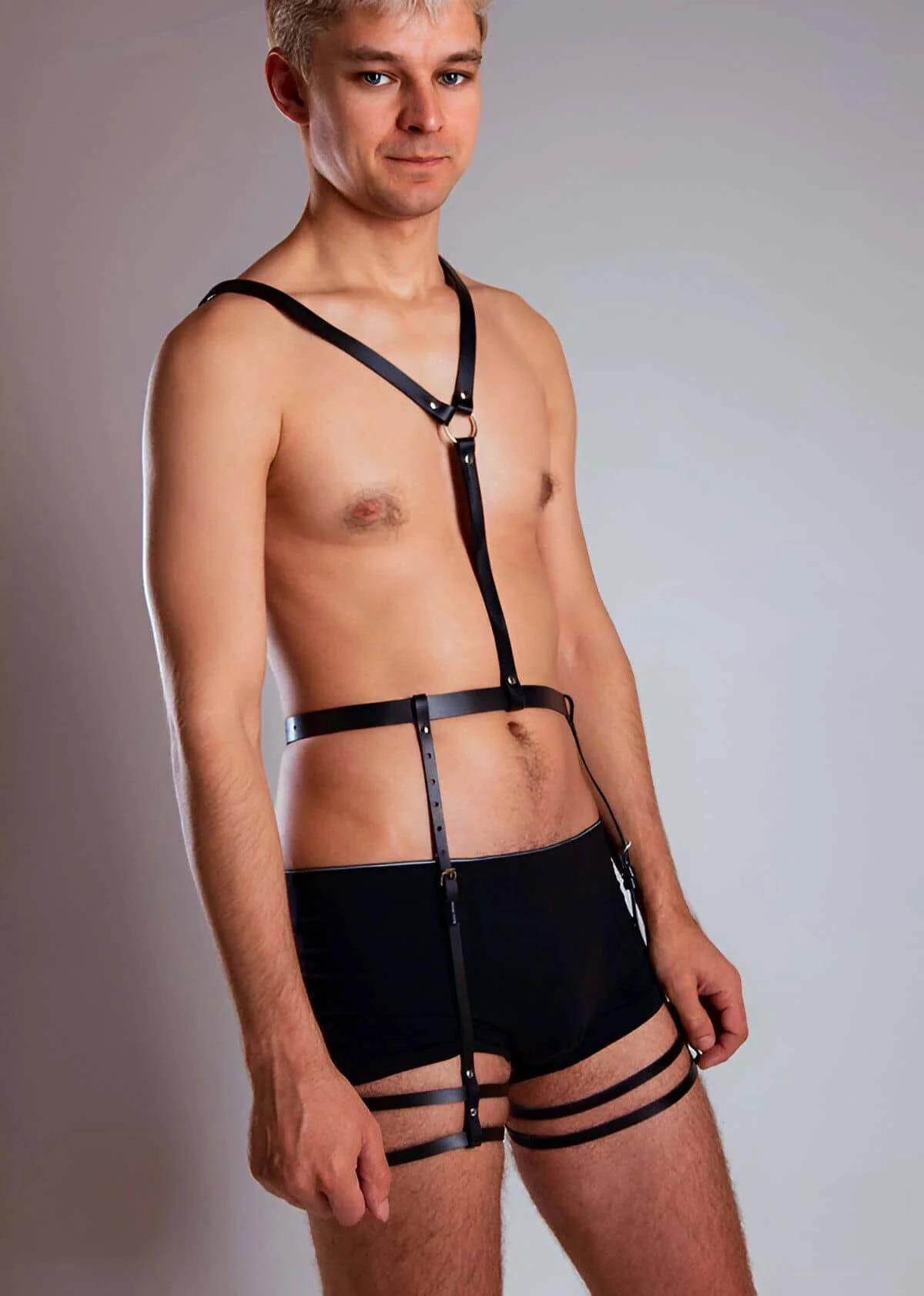 Black faux leather full body harness with gold O-ring at sternum, wide waist band, and double thigh straps worn by male model