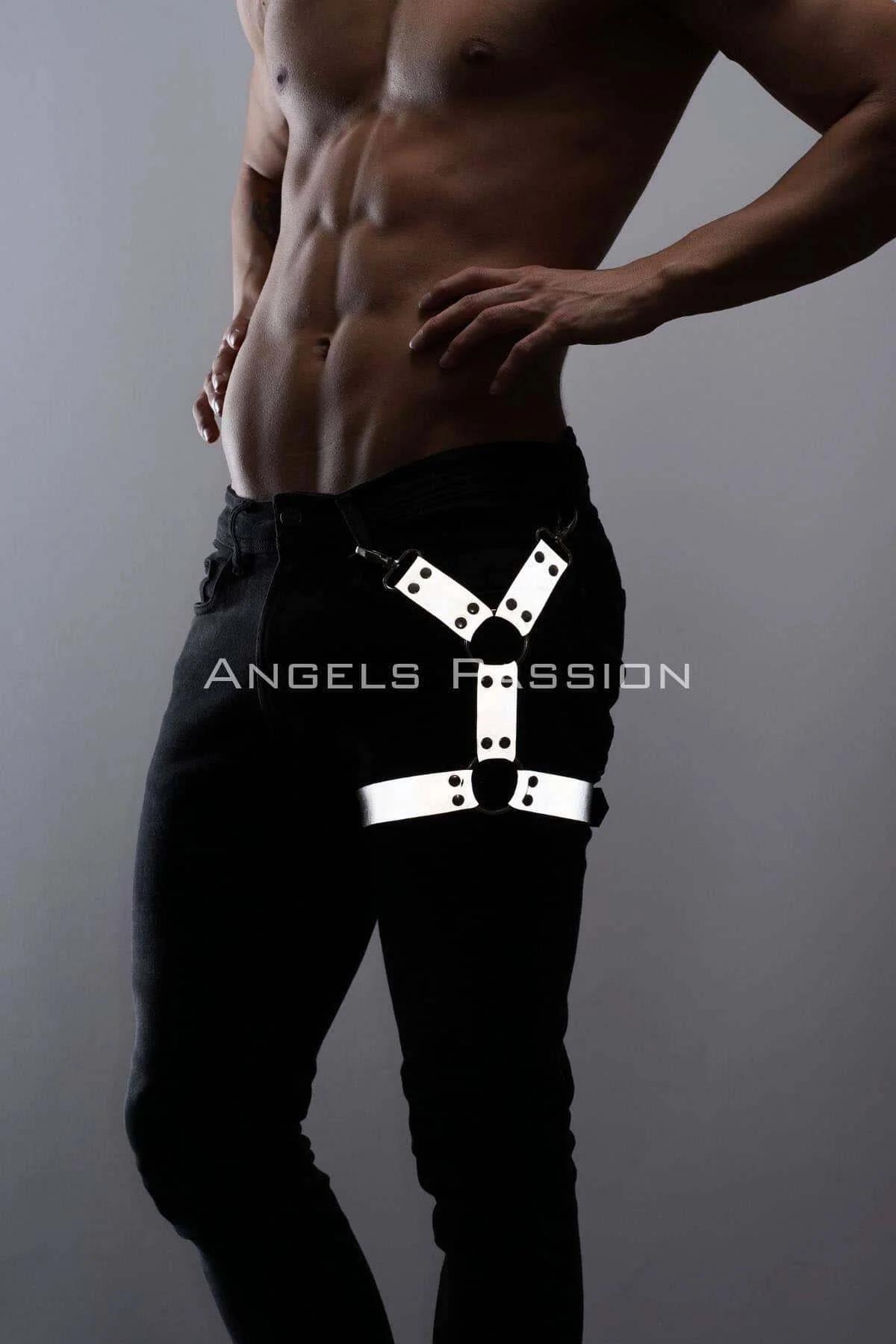 White reflective O-ring leg harness strap worn over black jeans with silver snap hardware on upper thigh