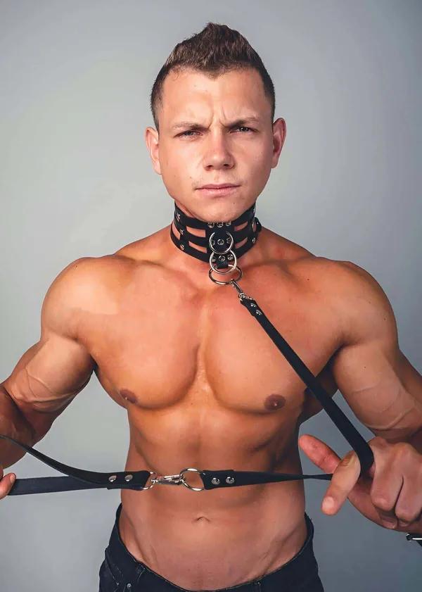 black faux leather quad strap body harness with stacked collar straps and silver O-rings worn by male model
