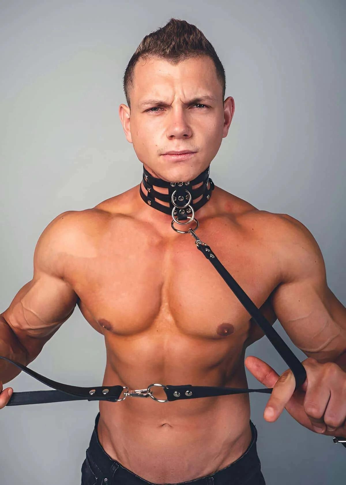 black faux leather quad strap body harness with stacked collar straps and silver O-rings worn by male model
