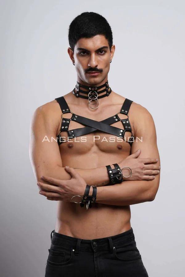 Black faux leather chest harness set with silver O-rings, triple-band collar, and wrist cuffs on male model