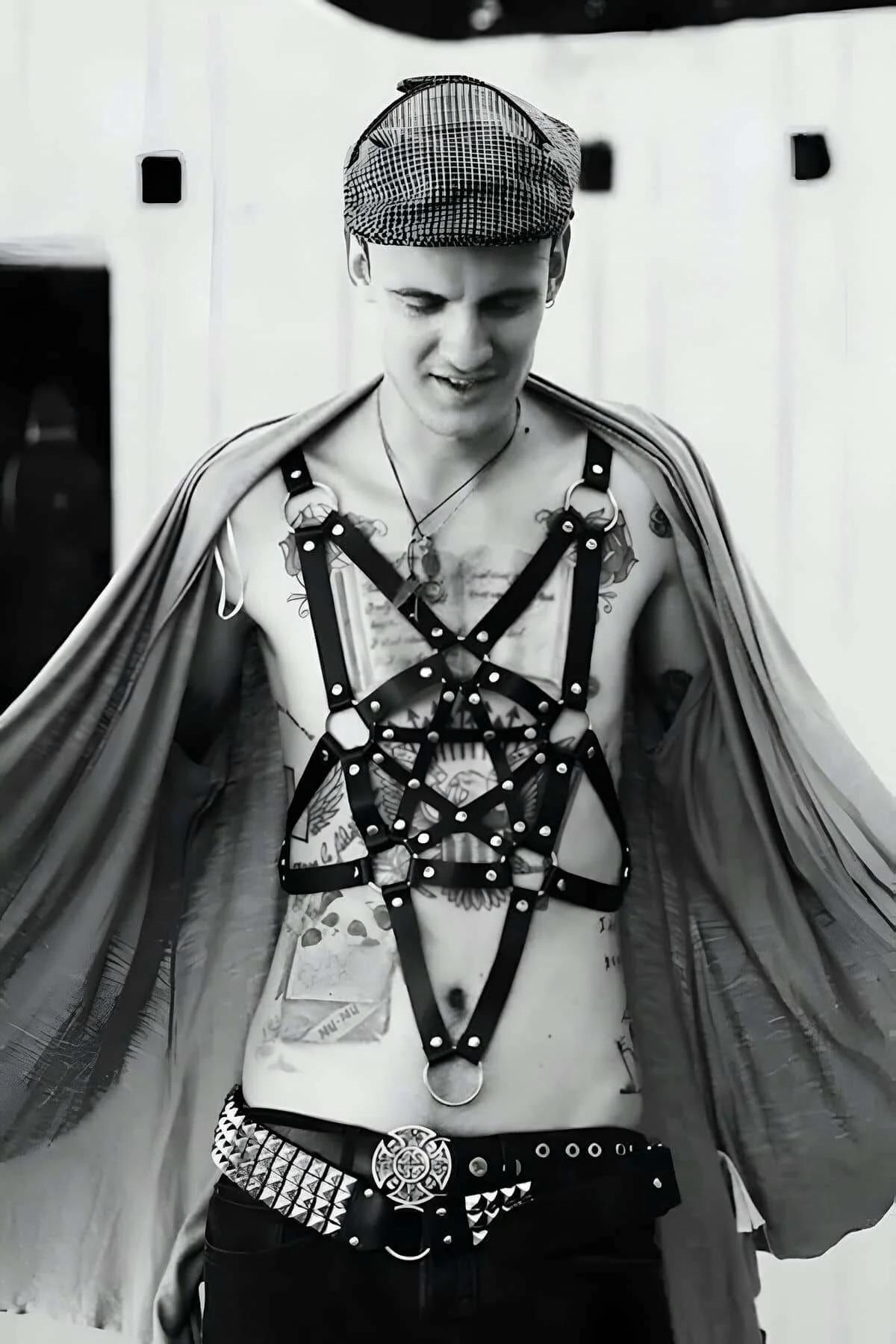 black faux leather star cage body harness with silver O-rings and rivets worn on male chest