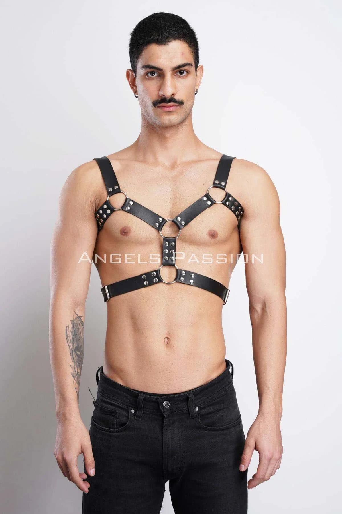 Black faux leather chest harness with silver dome studs and three O-rings worn by male model over bare torso