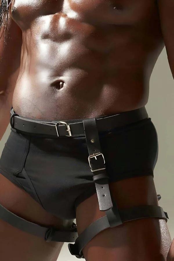 Black faux leather body harness with silver rectangular buckles, waist belt and wrap-around thigh straps on male model