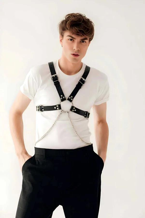 black faux leather chest harness with silver O-ring and chain detail worn over white t-shirt