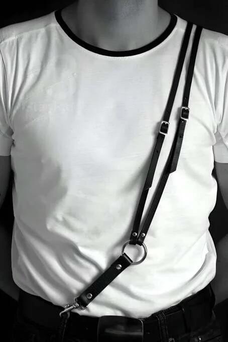 black faux leather chest harness with silver O-ring worn over white t-shirt diagonal strap adjustable mens